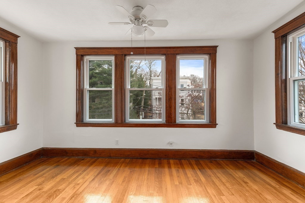 27 Union Street, Unit 3 Boston, MA 02135 - Photo 19 of 28 a view of an empty room with wooden floor and a window