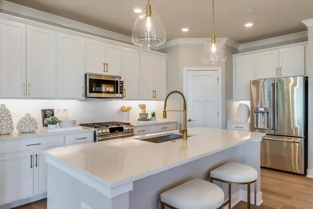 a kitchen with kitchen island a counter space a sink appliances and cabinets
