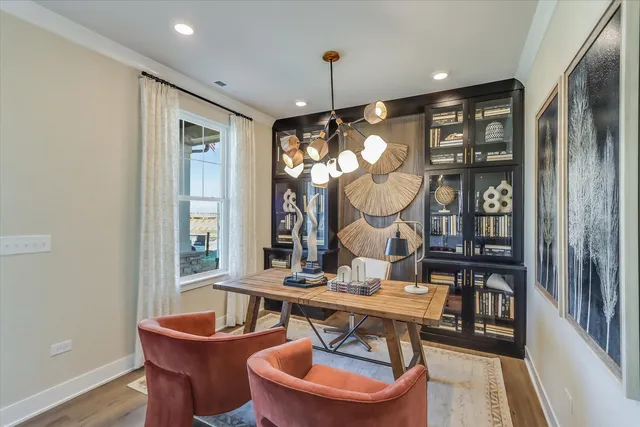 a view of a dining room with furniture a chandelier and wooden floor
