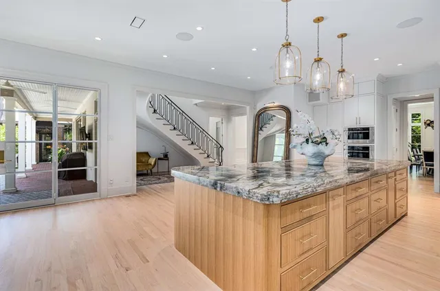 a kitchen with stainless steel appliances granite countertop a sink dishwasher a stove and a wooden floor with kitchen view