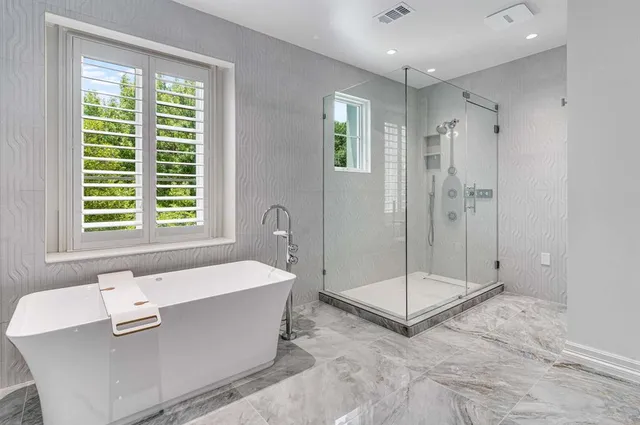 a bathroom with a tub a sink and a shower
