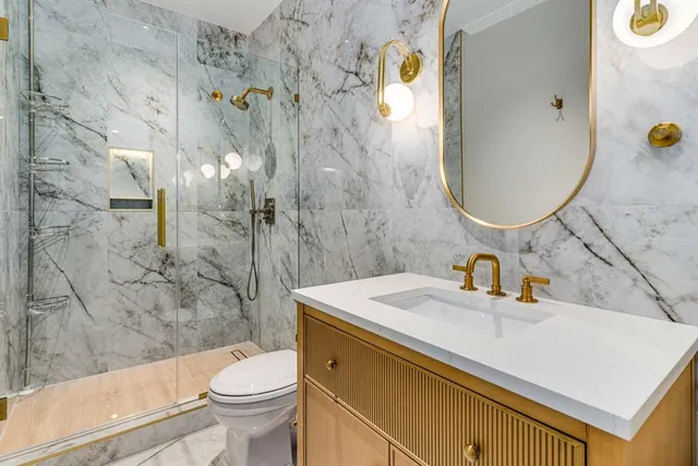 a bathroom with a sink a toilet and shower