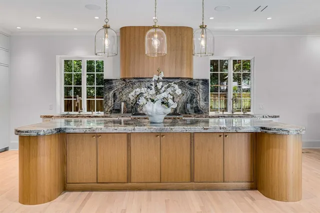a kitchen with kitchen island granite countertop a sink a counter top space and cabinets