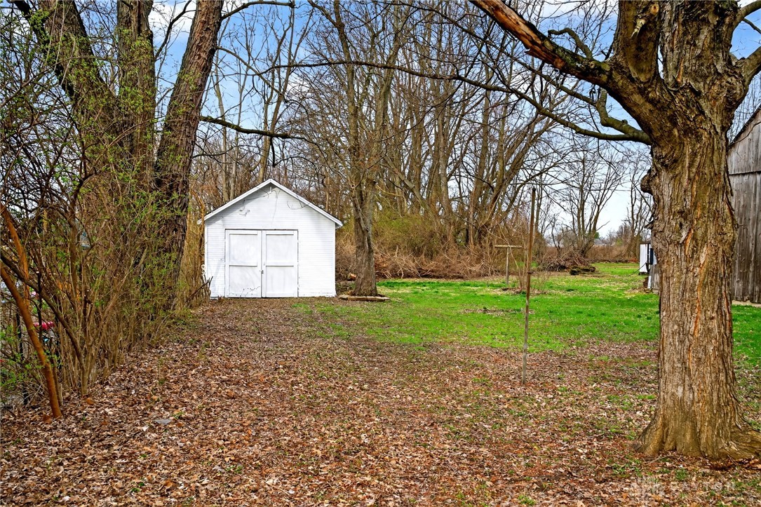 585 North Spring Street Wilmington, OH 45177 - Photo 20 of 21 This tranquil yard features a classic storage shed, perfect for outdoor essentials.