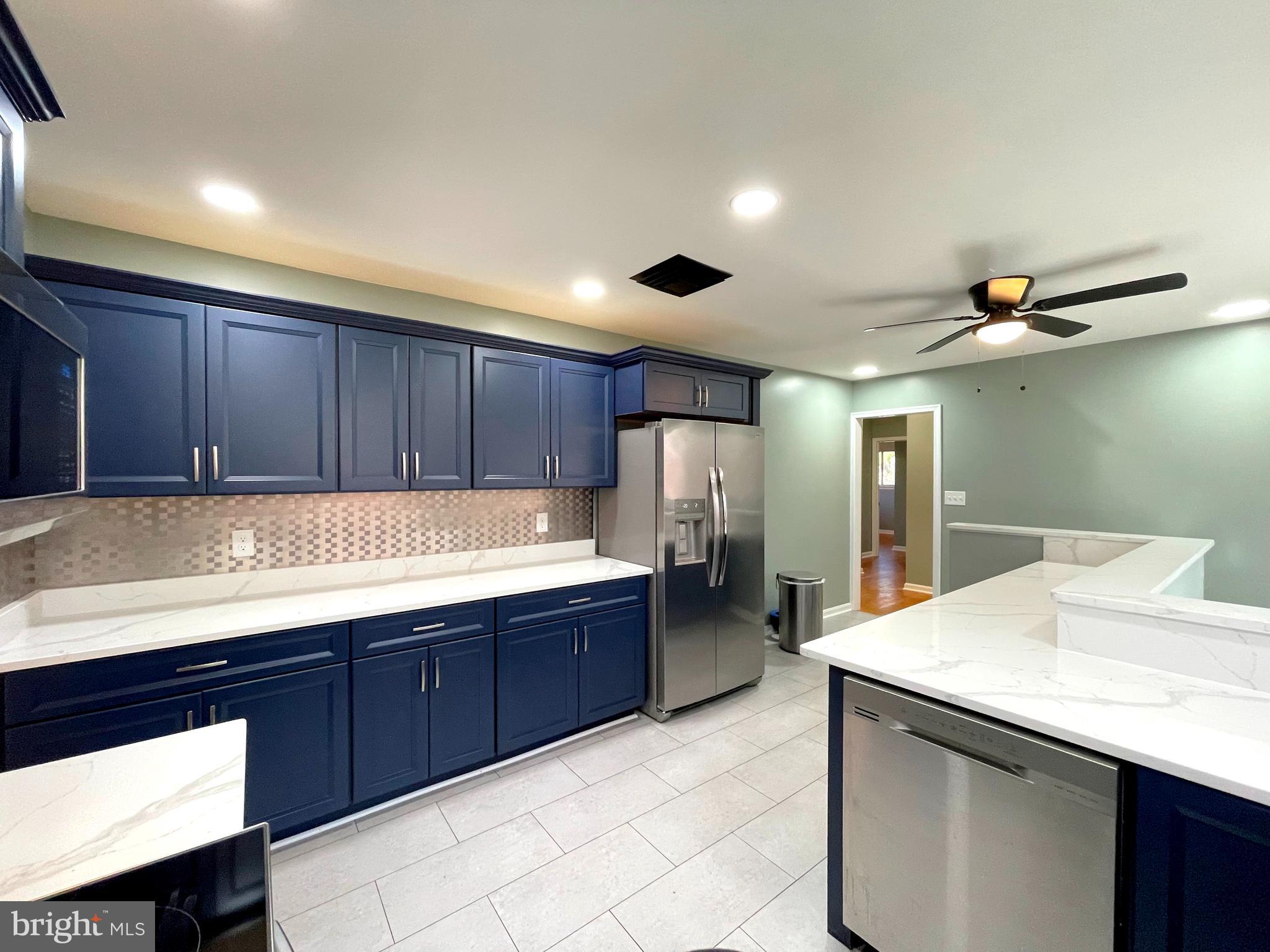 9457 Boyds Turn Road Owings, MD 20736 - Photo 13 of 46 a kitchen with stainless steel appliances kitchen island granite countertop a table chairs sink and cabinets