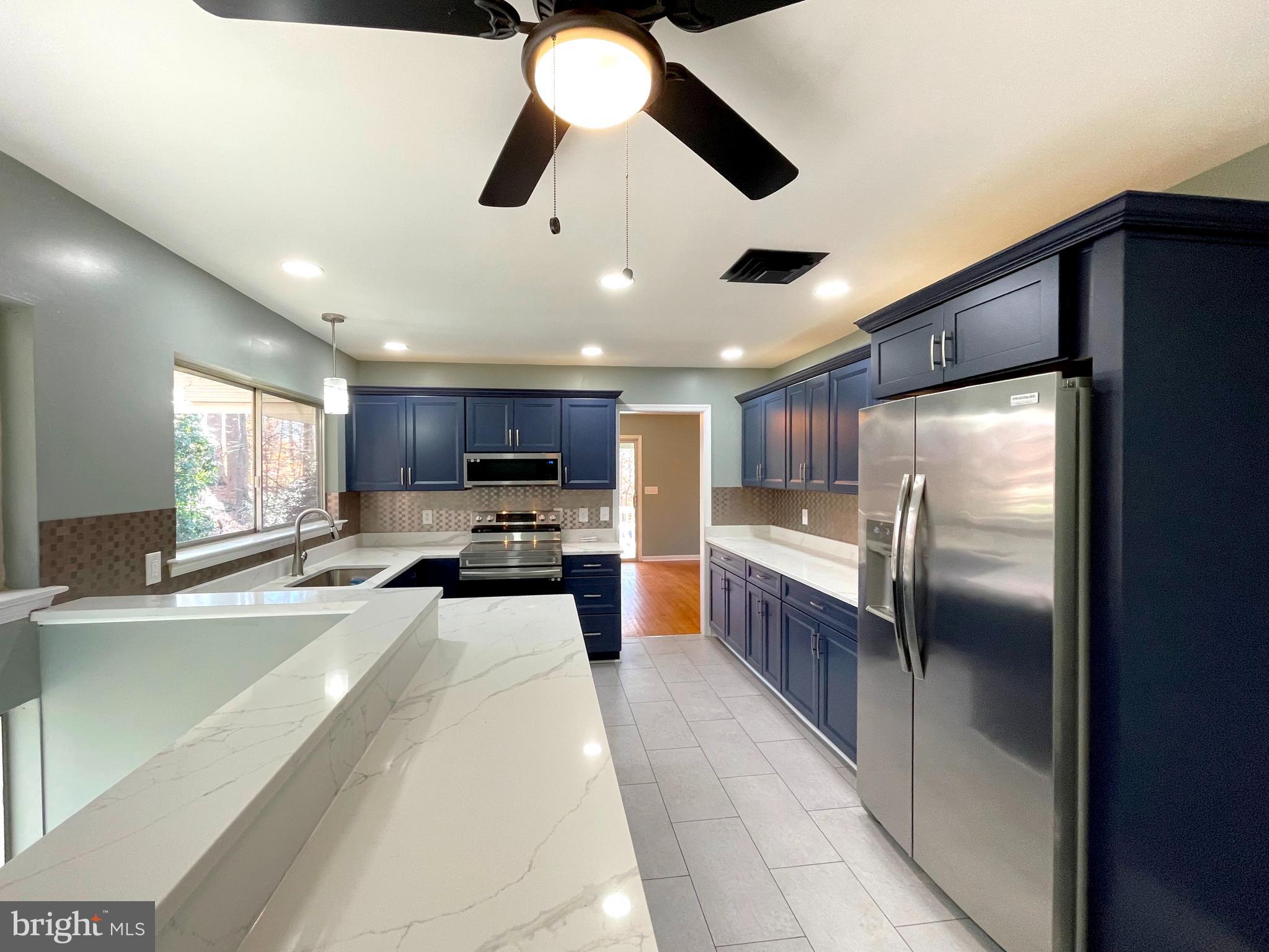 9457 Boyds Turn Road Owings, MD 20736 - Photo 15 of 46 a kitchen with stainless steel appliances kitchen island granite countertop a refrigerator and a sink