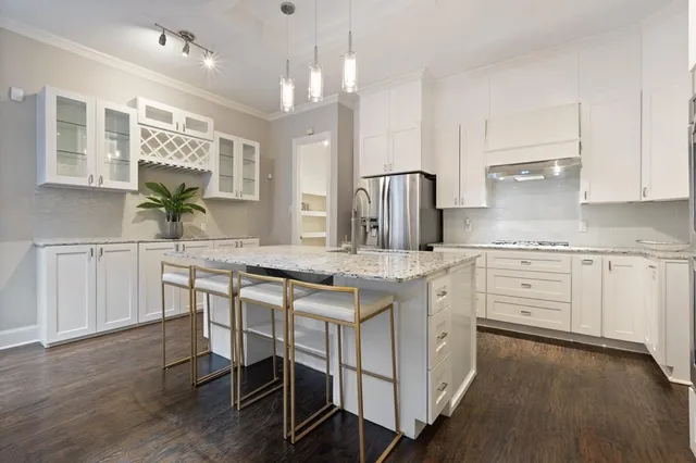 a kitchen with granite countertop white cabinets and chairs
