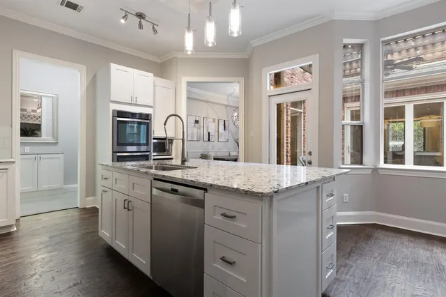 a kitchen with granite countertop a sink stove and cabinets