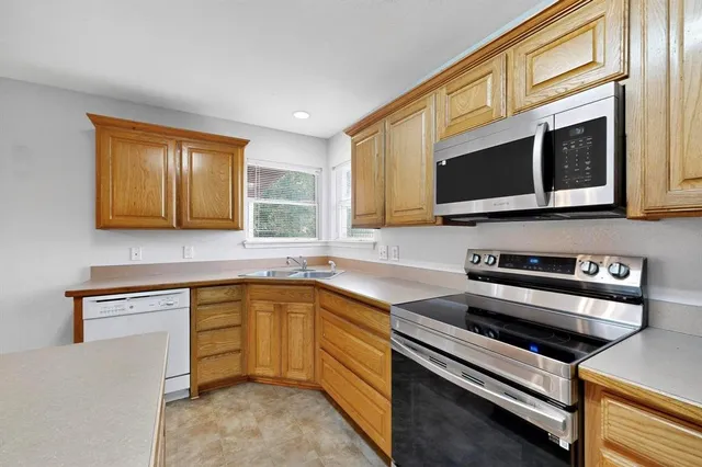 a kitchen with stainless steel appliances granite countertop a sink stove and microwave