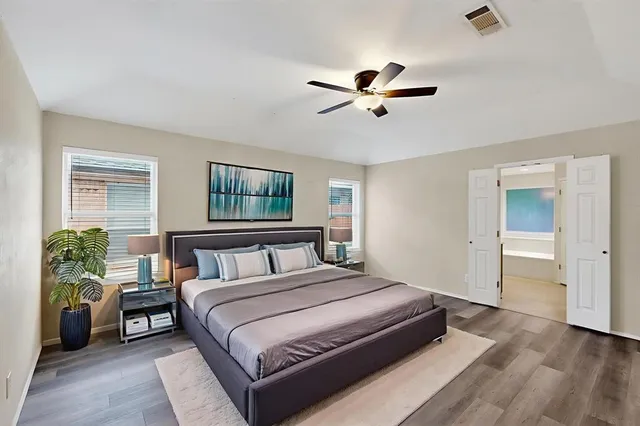 a bedroom with a large bed and windows