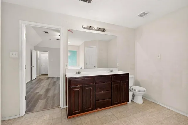 a bathroom with a sink vanity mirror and toilet