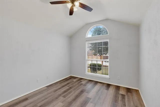 an empty room with a window and wooden floor