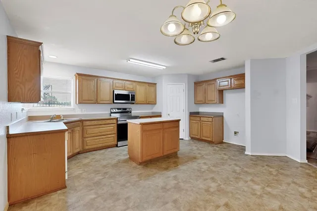 a kitchen with granite countertop a sink stainless steel appliances and cabinets