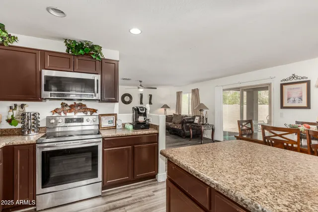 a kitchen with stainless steel appliances kitchen island granite countertop a stove and a sink