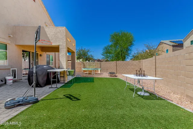 a backyard of a house with table and chairs