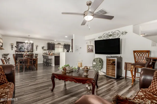 a living room with furniture a flat screen tv and kitchen view