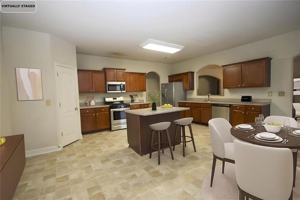 6074 Locklear Way Douglasville, GA 30134 - Photo 10 of 12 a kitchen with a table chairs microwave and cabinets