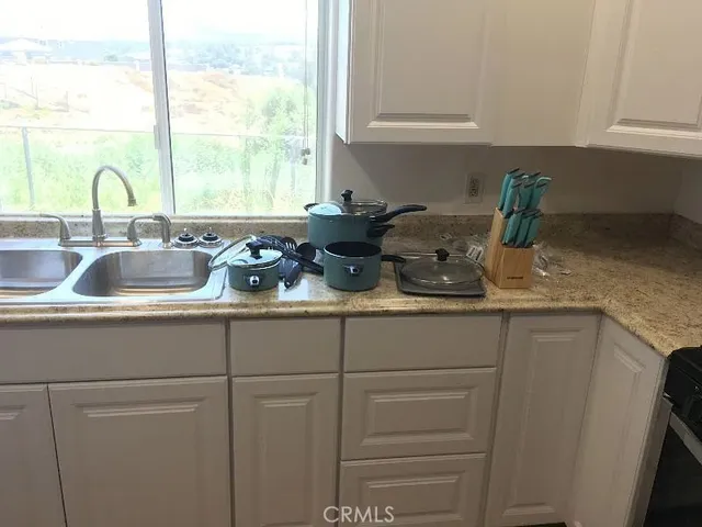 a kitchen with sink a window and cabinets