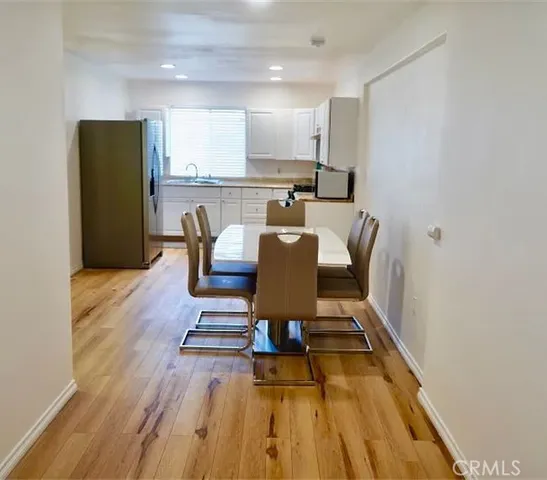 a view of a dining room with furniture a rug and wooden floor