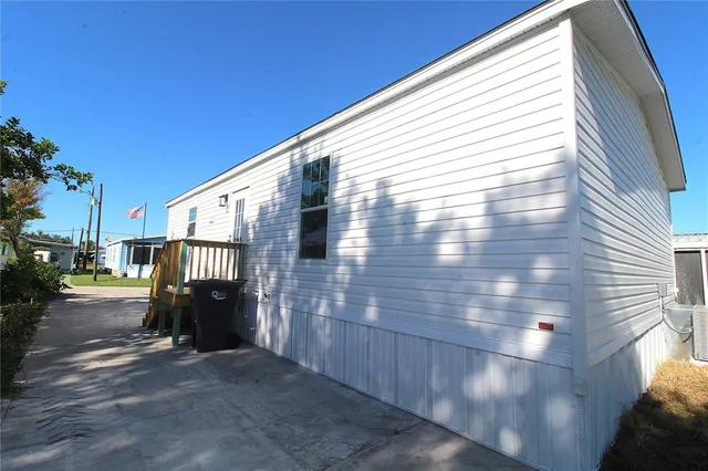 a view of road with card parked on side and retail shops