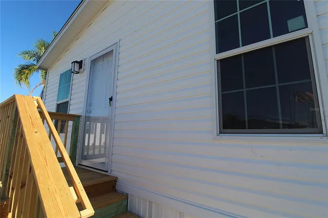 a kitchen with granite countertop a stove a sink a refrigerator wooden floor and cabinets
