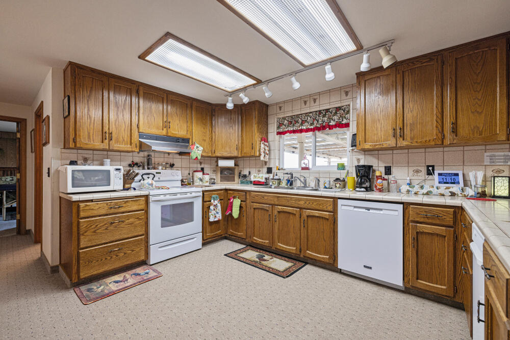 891 Cross Road Klamath Falls, OR 97603 - Photo 35 of 66 a kitchen with granite countertop a sink stainless steel appliances wooden cabinets and a window