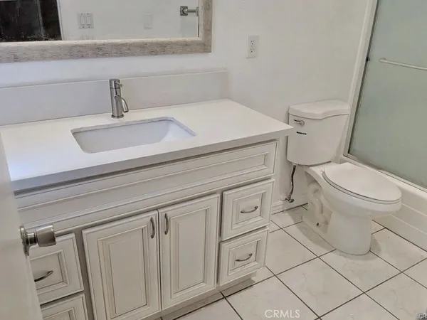 a white toilet sitting next to a bathroom sink