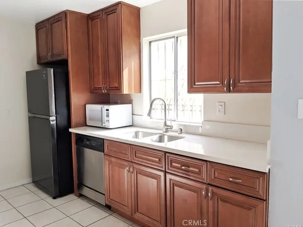 a kitchen with granite countertop wooden cabinets and stainless steel appliances