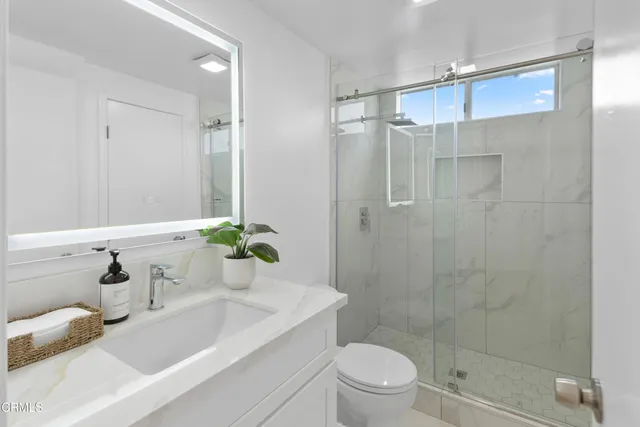 a bathroom with a sink a toilet and shower