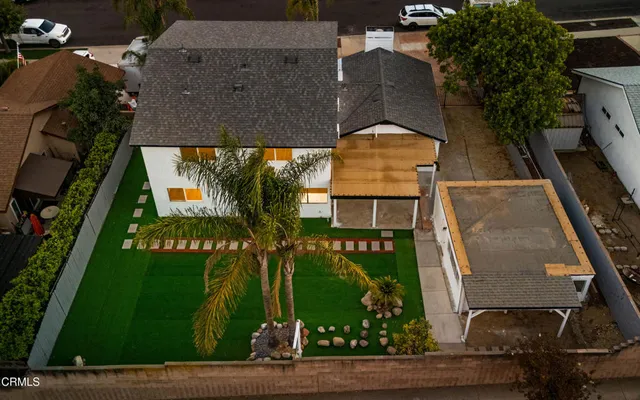 an aerial view of a residential houses with outdoor space and street view