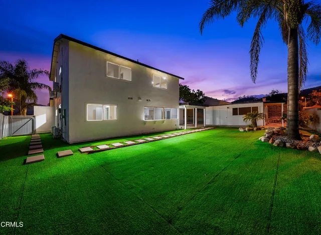 a view of a back yard of the house with a yard