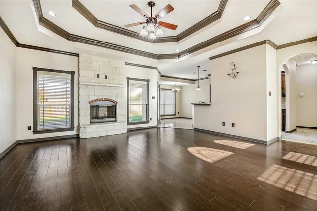 a view of empty room with fireplace and wooden floor
