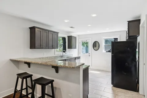 a kitchen with stainless steel appliances granite countertop a refrigerator and a sink