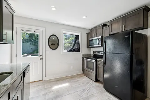 a kitchen with stainless steel appliances granite countertop a sink stove and cabinets