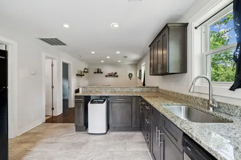 a kitchen with granite countertop cabinets sink and window