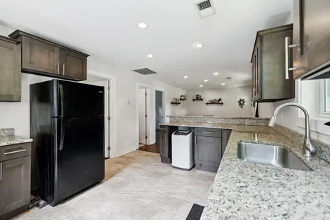 a kitchen with stainless steel appliances granite countertop a sink and refrigerator