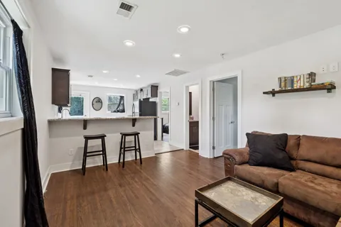 a living room with stainless steel appliances granite countertop a refrigerator and a sink