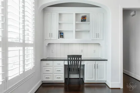 a kitchen with white cabinets and window