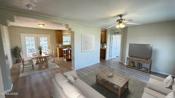a view of an empty room with window and wooden floor