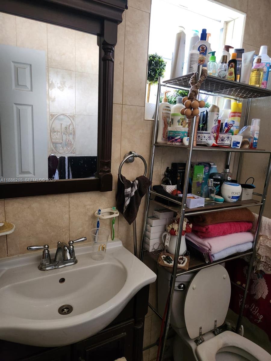 614 East 56th Street Hialeah, FL 33013 - Photo 23 of 78 a bathroom with a sink a toilet and a mirror