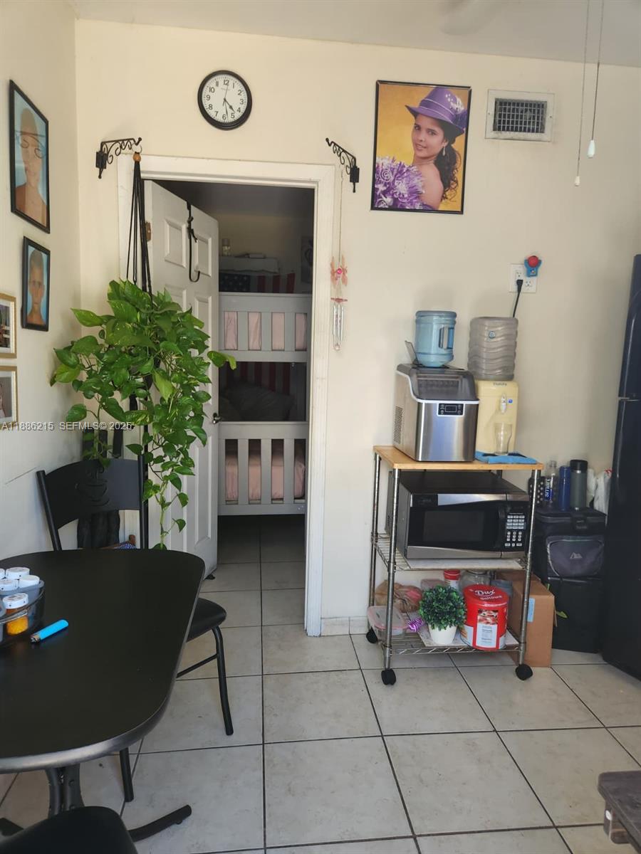 614 East 56th Street Hialeah, FL 33013 - Photo 29 of 78 a living room with furniture and a table with potted plants on the wall