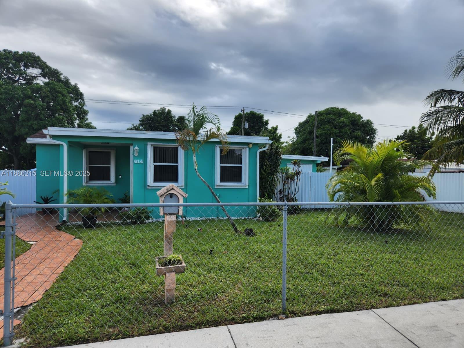 614 East 56th Street Hialeah, FL 33013 - Photo 3 of 78 a front view of house with a garden and yard