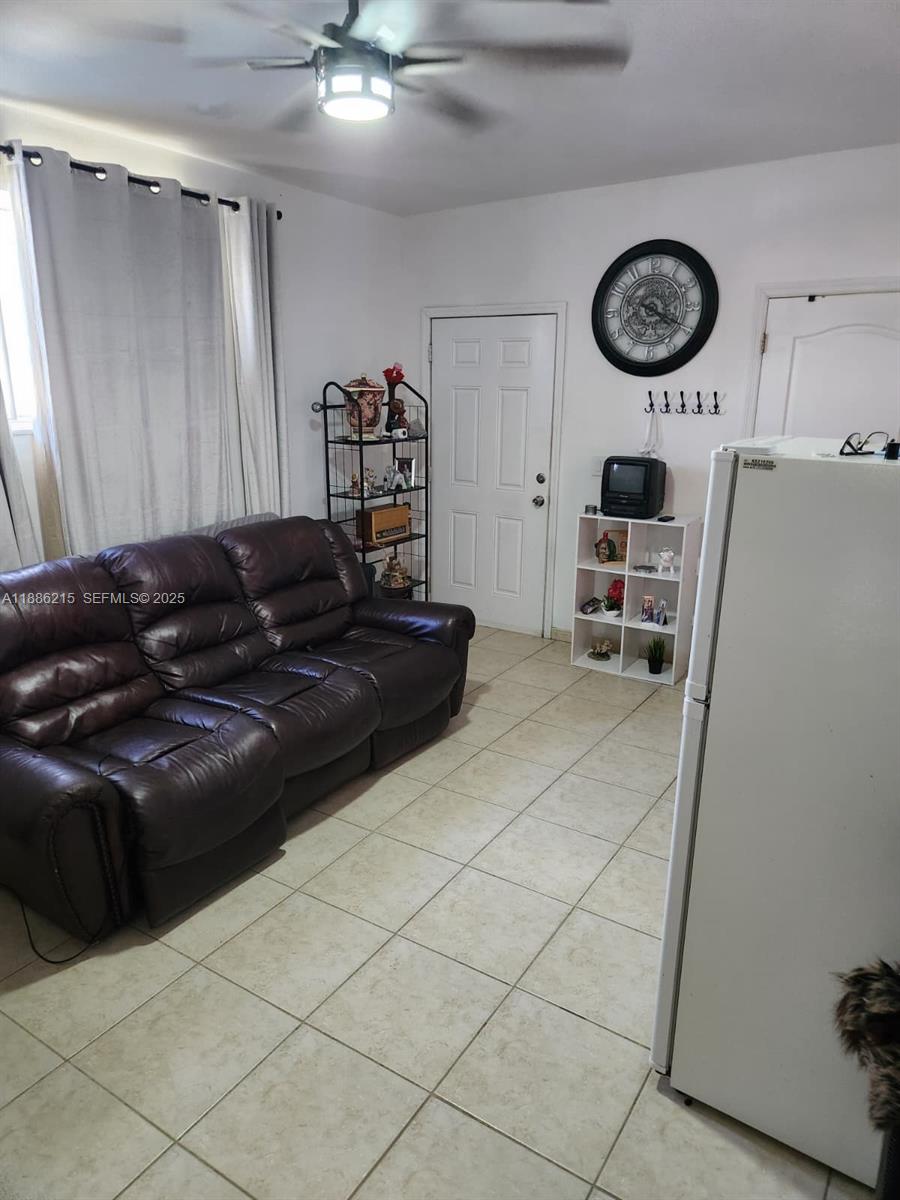 614 East 56th Street Hialeah, FL 33013 - Photo 53 of 78 a black leather couch sitting in a kitchen with stainless steel appliances a cabinet and a refrigerator