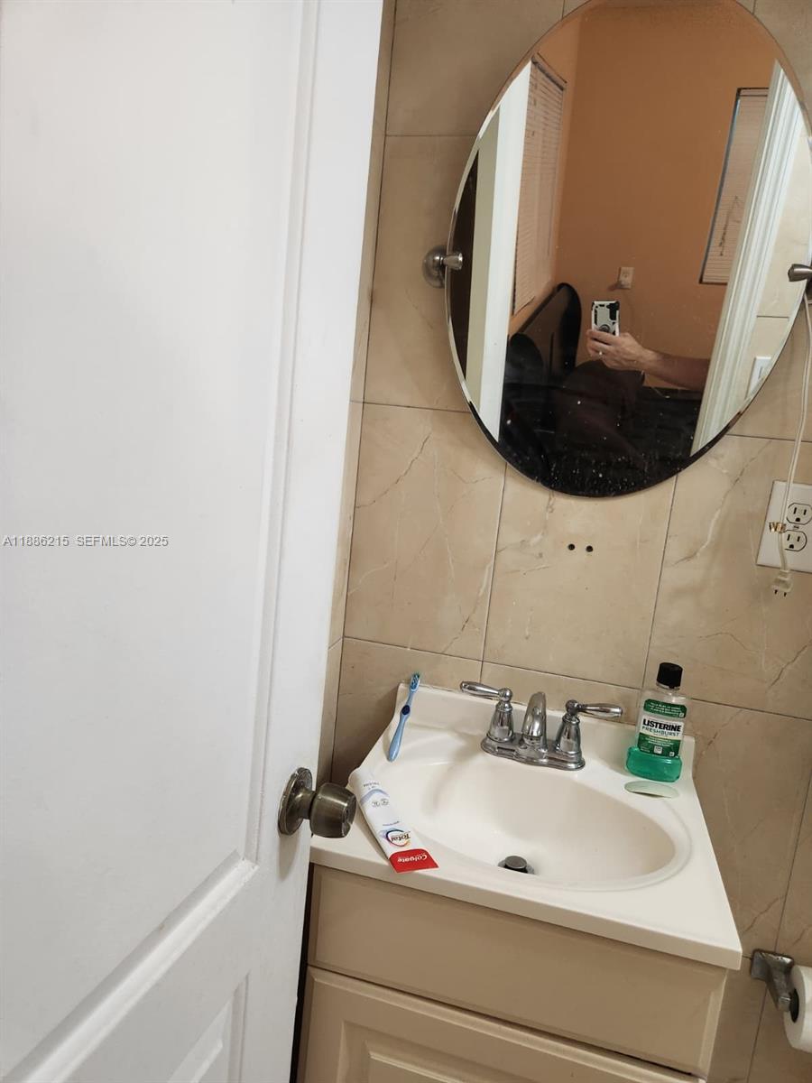 614 East 56th Street Hialeah, FL 33013 - Photo 65 of 78 a bathroom with a sink and mirror