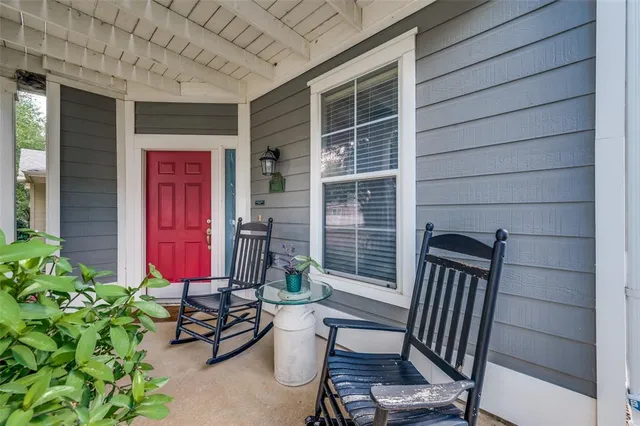 a view of a porch with chairs and potted plants