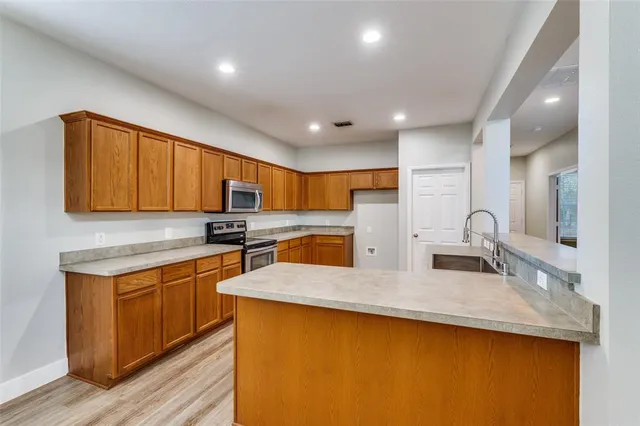 a kitchen with stainless steel appliances granite countertop a sink stove and cabinets