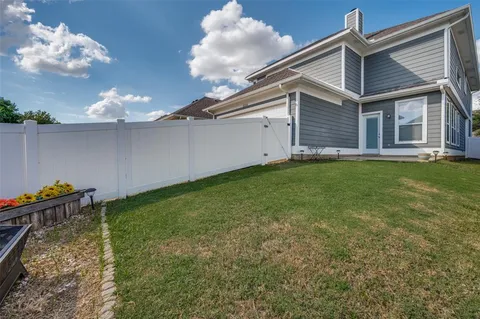 a backyard of a house with table and chairs