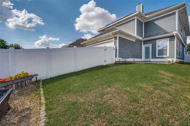 a backyard of a house with table and chairs