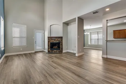 an empty room with wooden floor and fireplace