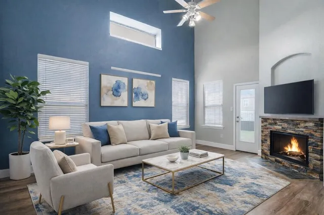 a living room with furniture a flat screen tv and a fireplace